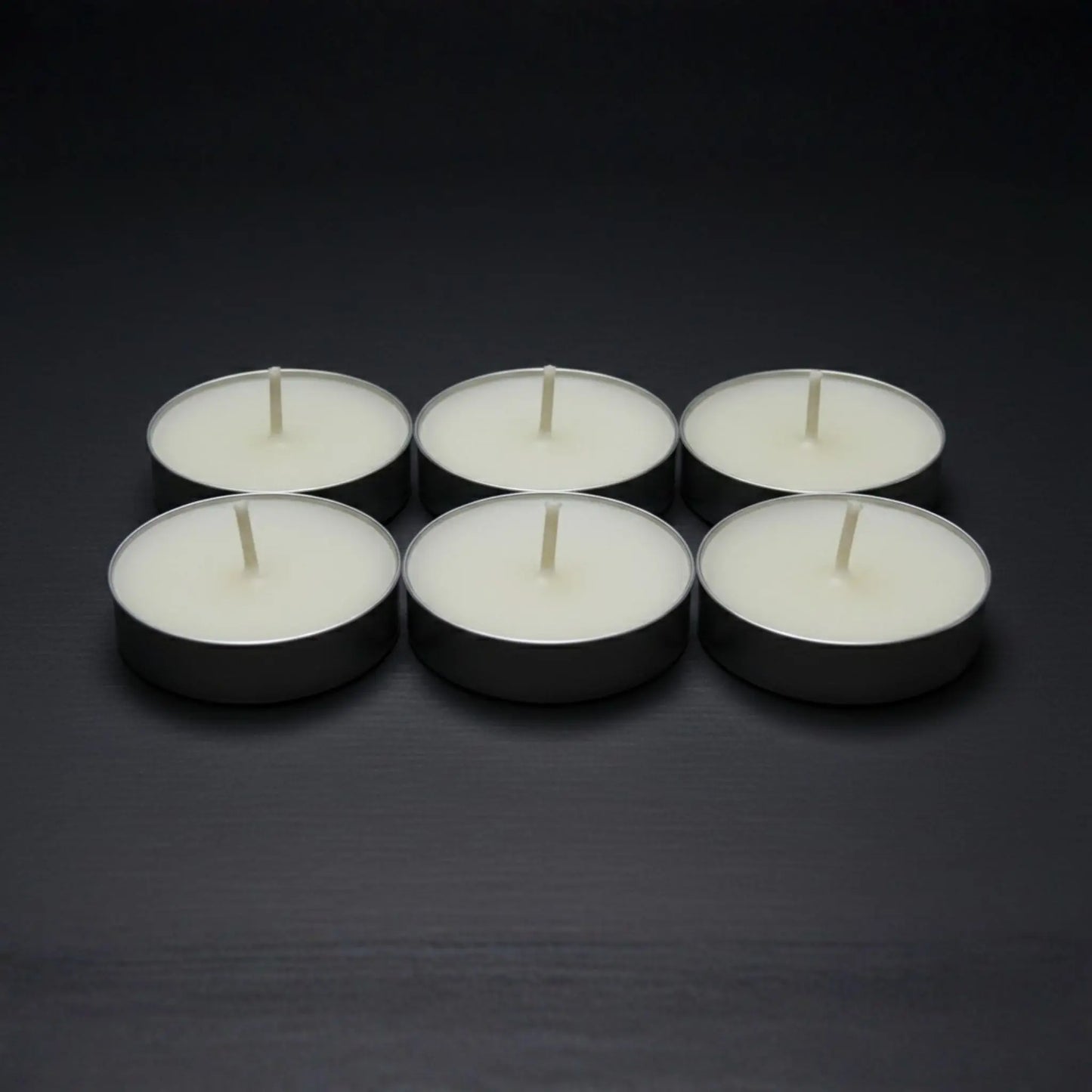 Odrius kokusuz 6’lı tealight mum seti, kutusunda sunulmuş ve arkada yanan seramik buhurdanlık ile kullanımda
