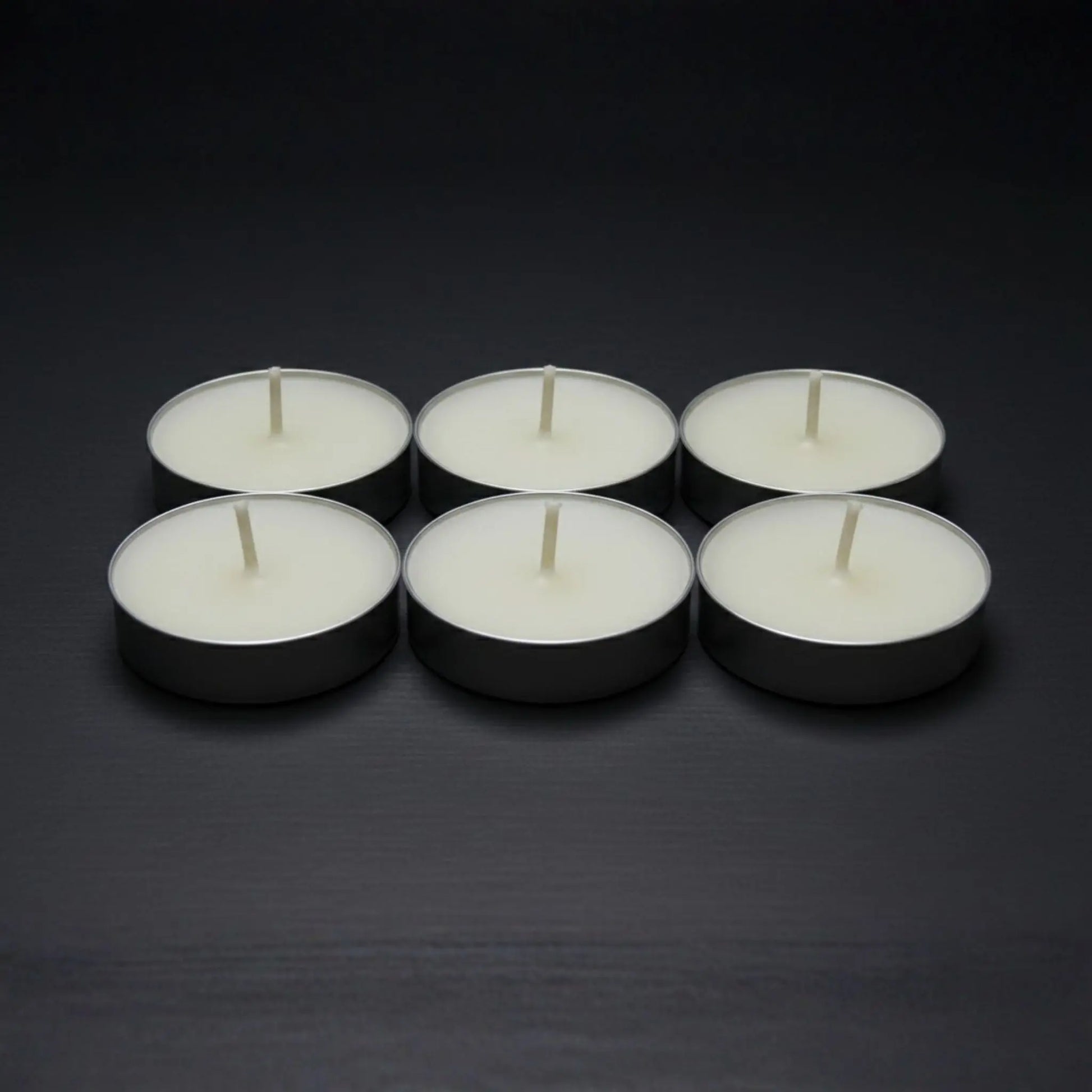 Odrius kokusuz 6’lı tealight mum seti, kutusunda sunulmuş ve arkada yanan seramik buhurdanlık ile kullanımda
