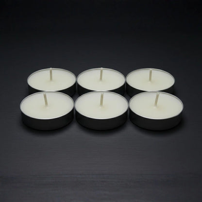 Odrius kokusuz 6’lı tealight mum seti, kutusunda sunulmuş ve arkada yanan seramik buhurdanlık ile kullanımda