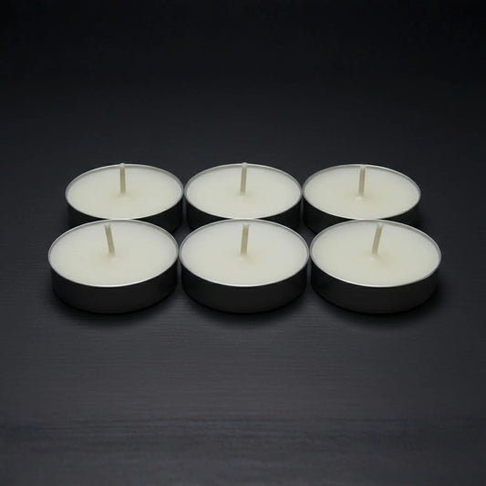 Odrius kokusuz 6’lı tealight mum seti, kutusunda sunulmuş ve arkada yanan seramik buhurdanlık ile kullanımda